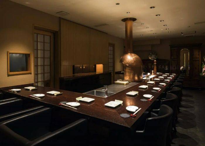 The stylish interiors of Kitashinchi Kushikatsu Bon in Osaka, featuring low lighting and dark woods.